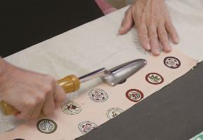 A dressmaker uses an iron kote