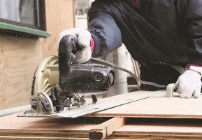 An architectural carpenter cut the board with an electric saw